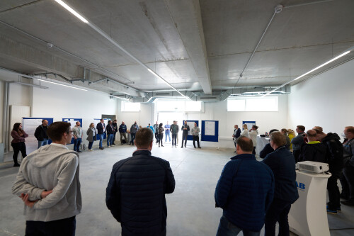 In a hall people stand in a large circle