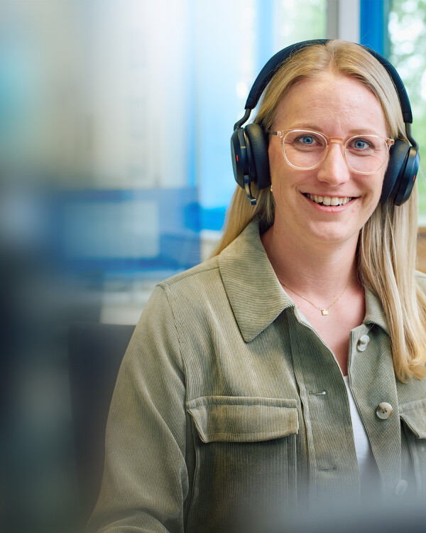 Produktmanagerin im Büro mit Headset.