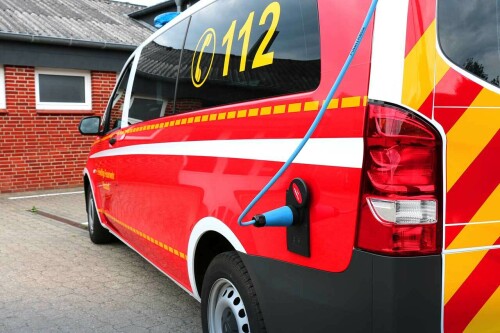 Ein blaues Ladekabel steckt in einem Feuerwehrwagen in Busdorf