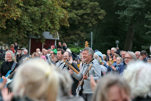 Menschenmenge hinter Musikern mit Instrumenten