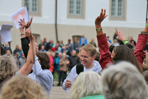 Ministerpaäsident Daniel Günther lacht mit Mikrofon in der Hand