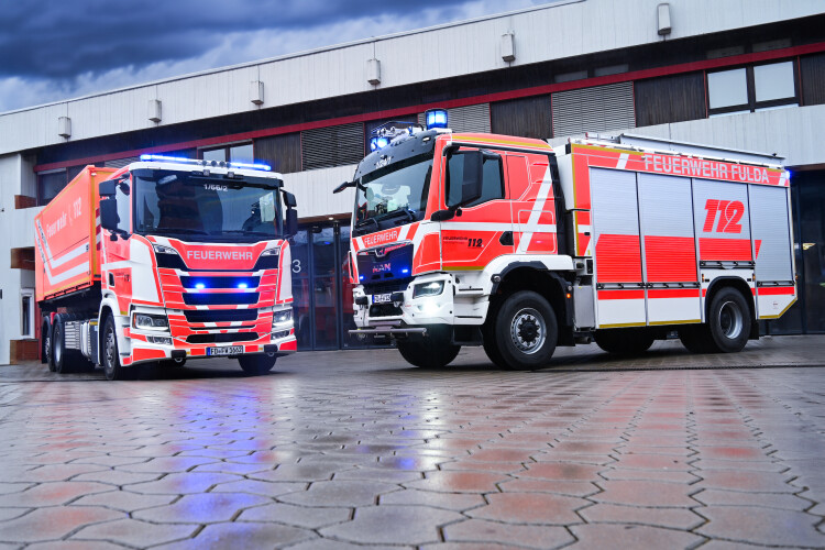 Zwei Feuerwehrwagen der Feuerwehr Fulda stehen vor der Garage.