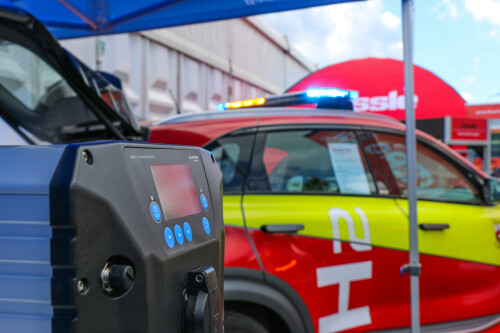 A blue Melfbox stands in front of an emergency vehicle