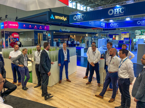 People in suits chatting at an ANGA trade fair stand