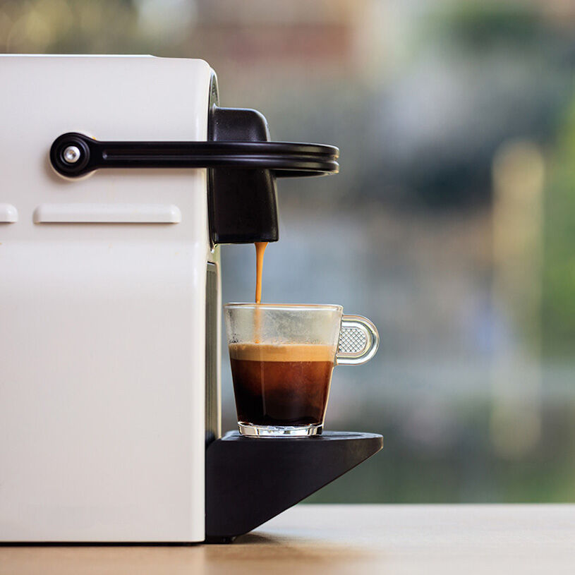 Espresso runs out of machine into a cup